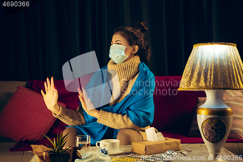 Image of Woman wrapped in a plaid wearing face mask trying to protect from somebody\'s sick