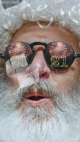 Image of Close-up Santa Claus in glasses with a reflection of 2021 Happy New Year