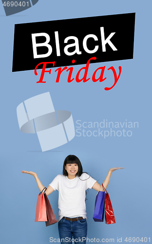 Image of Beautiful woman inviting for shopping in black friday, sales concept. Vertical flyer, blue background