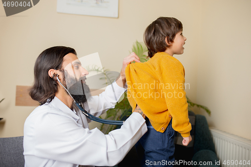 Image of Paediatrician doctor examining a child in comfortabe medical office