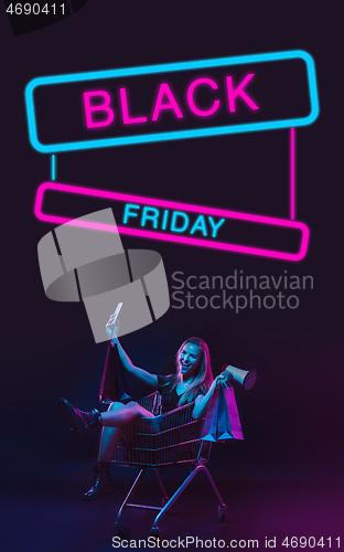 Image of Beautiful woman inviting for shopping in black friday, sales concept. Vertical flyer, neoned style, dark background