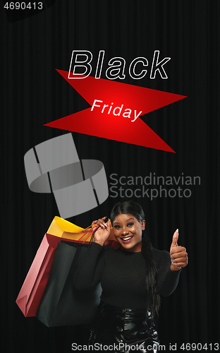 Image of Beautiful woman inviting for shopping in black friday, sales concept. Vertical flyer, dark background