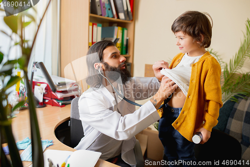 Image of Paediatrician doctor examining a child in comfortabe medical office