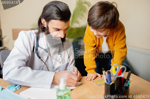 Image of Paediatrician doctor examining a child in comfortabe medical office