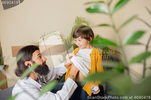 Image of Paediatrician doctor examining a child in comfortabe medical office