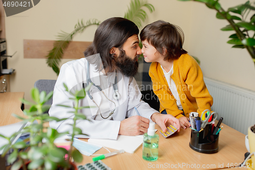 Image of Paediatrician doctor examining a child in comfortabe medical office