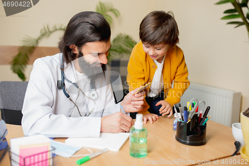 Image of Paediatrician doctor examining a child in comfortabe medical office