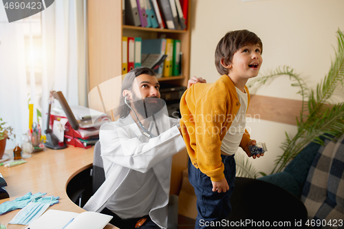 Image of Paediatrician doctor examining a child in comfortabe medical office