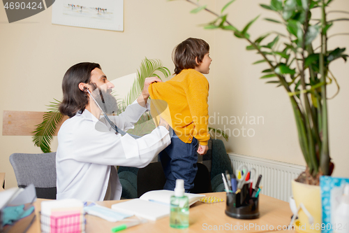 Image of Paediatrician doctor examining a child in comfortabe medical office