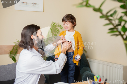 Image of Paediatrician doctor examining a child in comfortabe medical office