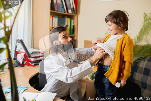 Image of Paediatrician doctor examining a child in comfortabe medical office