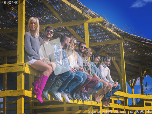 Image of Group of friends having fun on autumn day at beach