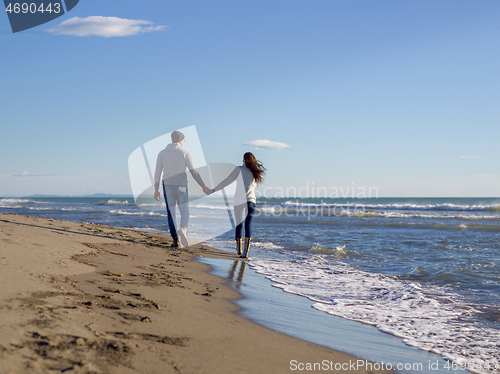 Image of Loving young couple on a beach at autumn sunny day