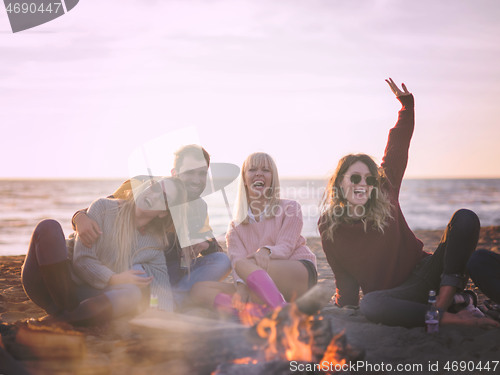 Image of Friends having fun at beach on autumn day