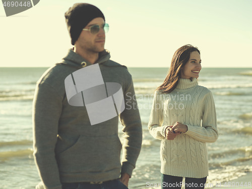 Image of Loving young couple on a beach at autumn sunny day