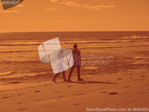 Image of Loving young couple on a beach at autumn sunny day