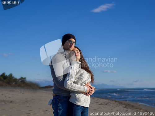 Image of Loving young couple on a beach at autumn sunny day