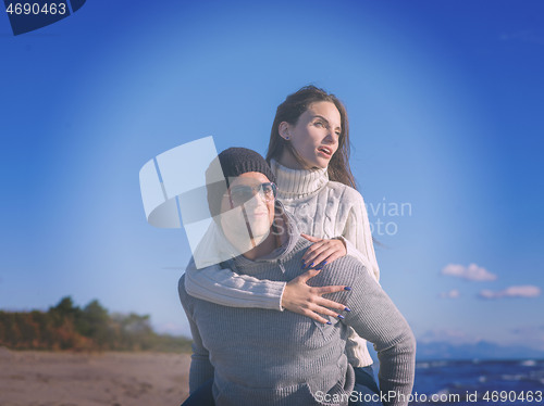 Image of couple having fun at beach during autumn