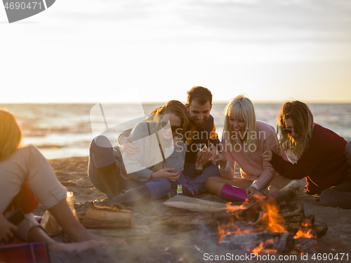 Image of Friends having fun at beach on autumn day