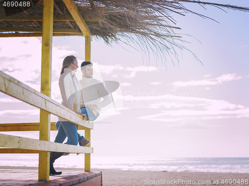 Image of young couple drinking beer together at the beach