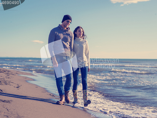 Image of Loving young couple on a beach at autumn sunny day