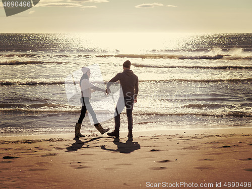 Image of Loving young couple on a beach at autumn sunny day