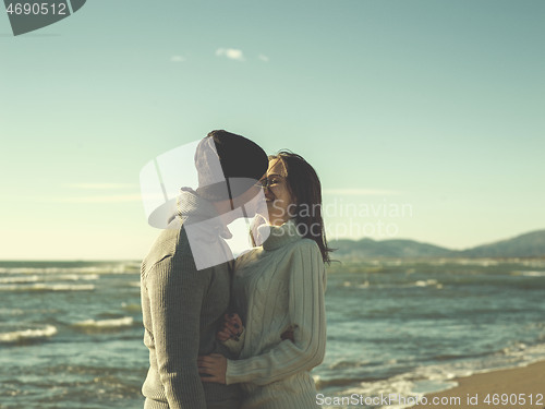 Image of Loving young couple on a beach at autumn sunny day