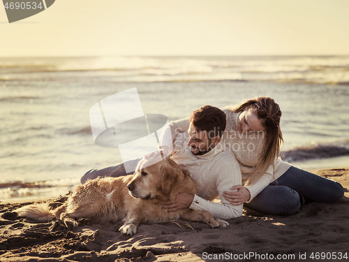 Image of Couple with dog enjoying time on beach