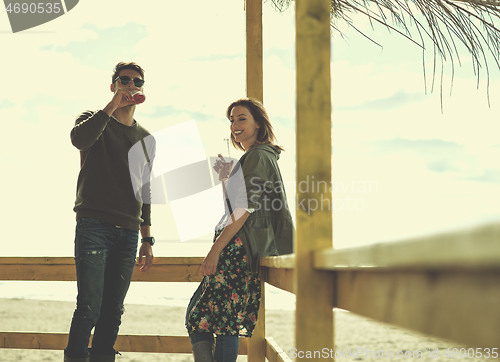 Image of young couple drinking beer together at the beach