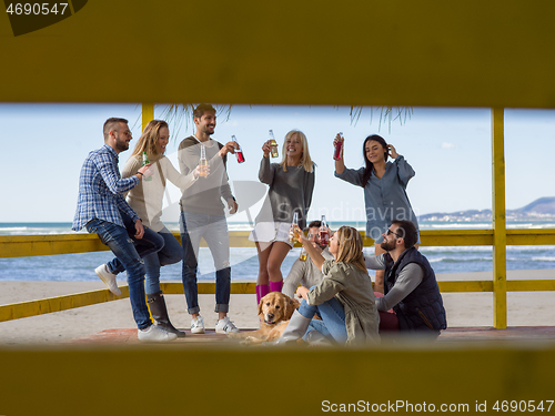 Image of Group of friends having fun on autumn day at beach