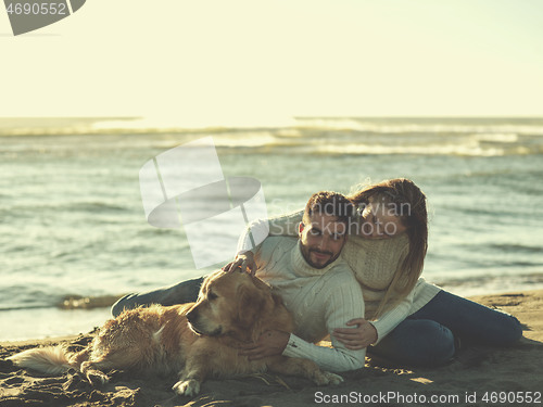 Image of Couple with dog enjoying time on beach