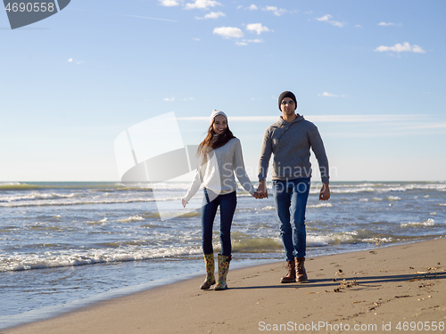 Image of Loving young couple on a beach at autumn sunny day