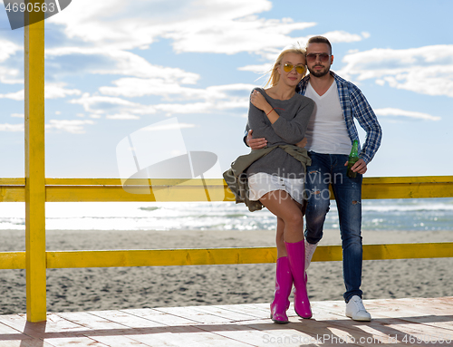 Image of young couple drinking beer together at the beach