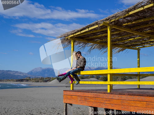 Image of young couple drinking beer together at the beach