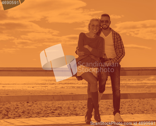 Image of young couple drinking beer together at the beach