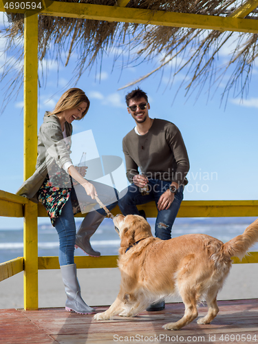 Image of young couple with a dog at the beach