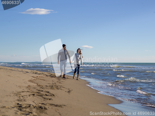 Image of Loving young couple on a beach at autumn sunny day