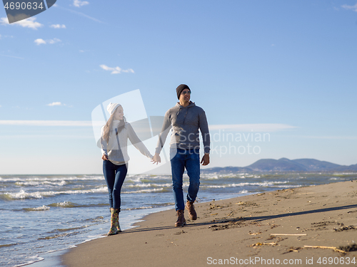 Image of Loving young couple on a beach at autumn sunny day