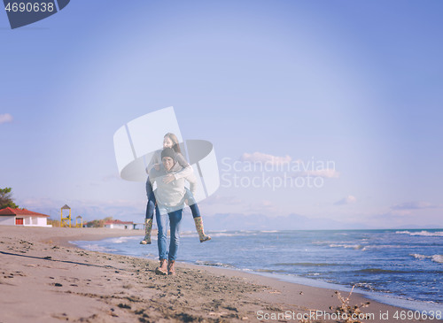 Image of couple having fun at beach during autumn