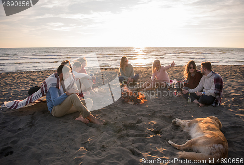 Image of Friends having fun at beach on autumn day