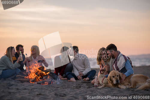 Image of Friends having fun at beach on autumn day