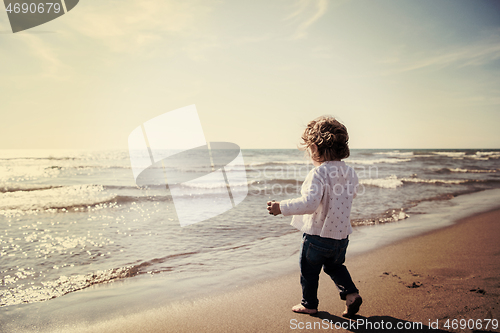 Image of cute little girl at autumn beach