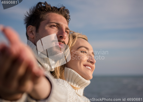 Image of Loving young couple on a beach at autumn sunny day