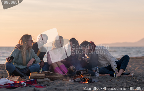 Image of Friends having fun at beach on autumn day