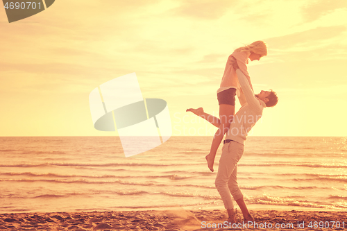 Image of Loving young couple on a beach at autumn sunny day