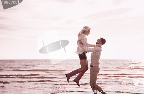 Image of Loving young couple on a beach at autumn sunny day