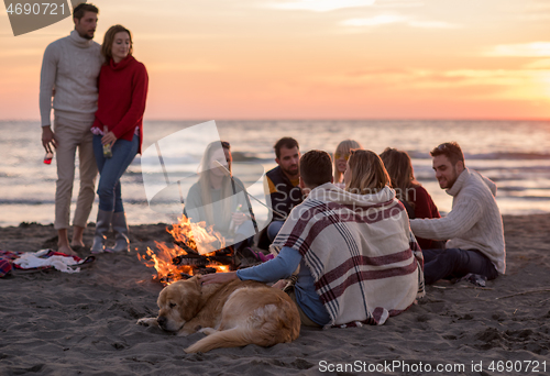 Image of Friends having fun at beach on autumn day