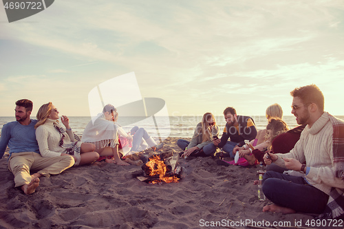 Image of Friends having fun at beach on autumn day