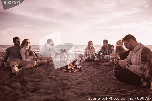 Image of Friends having fun at beach on autumn day