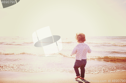 Image of cute little girl at autumn beach